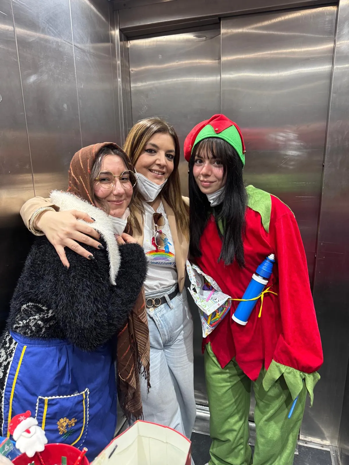 Tre volontarie con i costumi della Befana e di un elfo